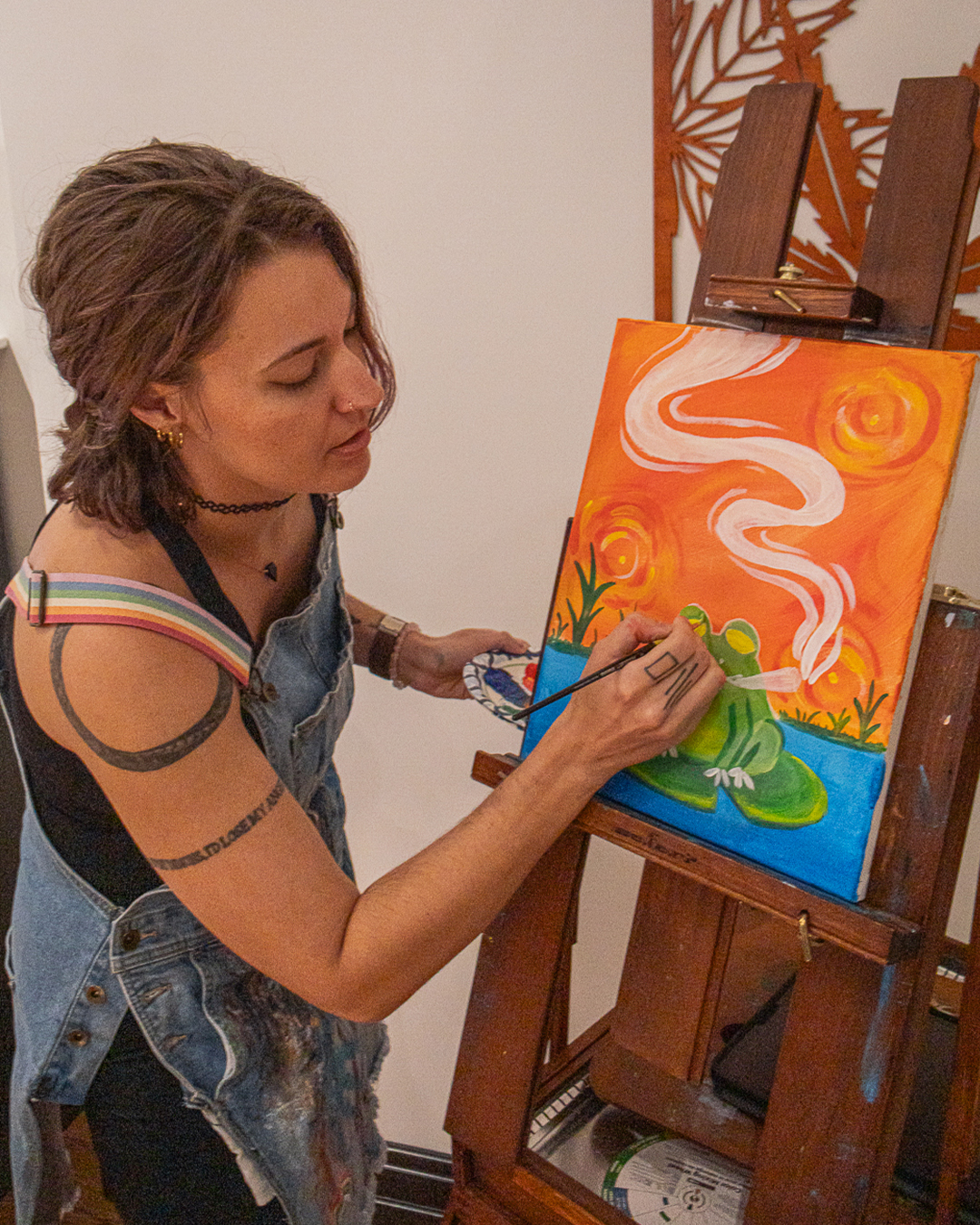 Artist painting at an easel during the Puff N Paint class at 6 Point Flower Shop