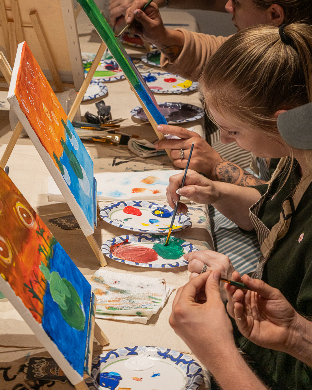 Guests painting at easels during the Puff N Paint night at 6 Point Flower Shop